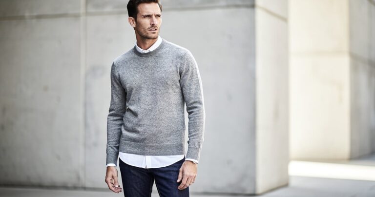 Homme portant un pull gris chiné col rond avec chemise blanche et jean indigo